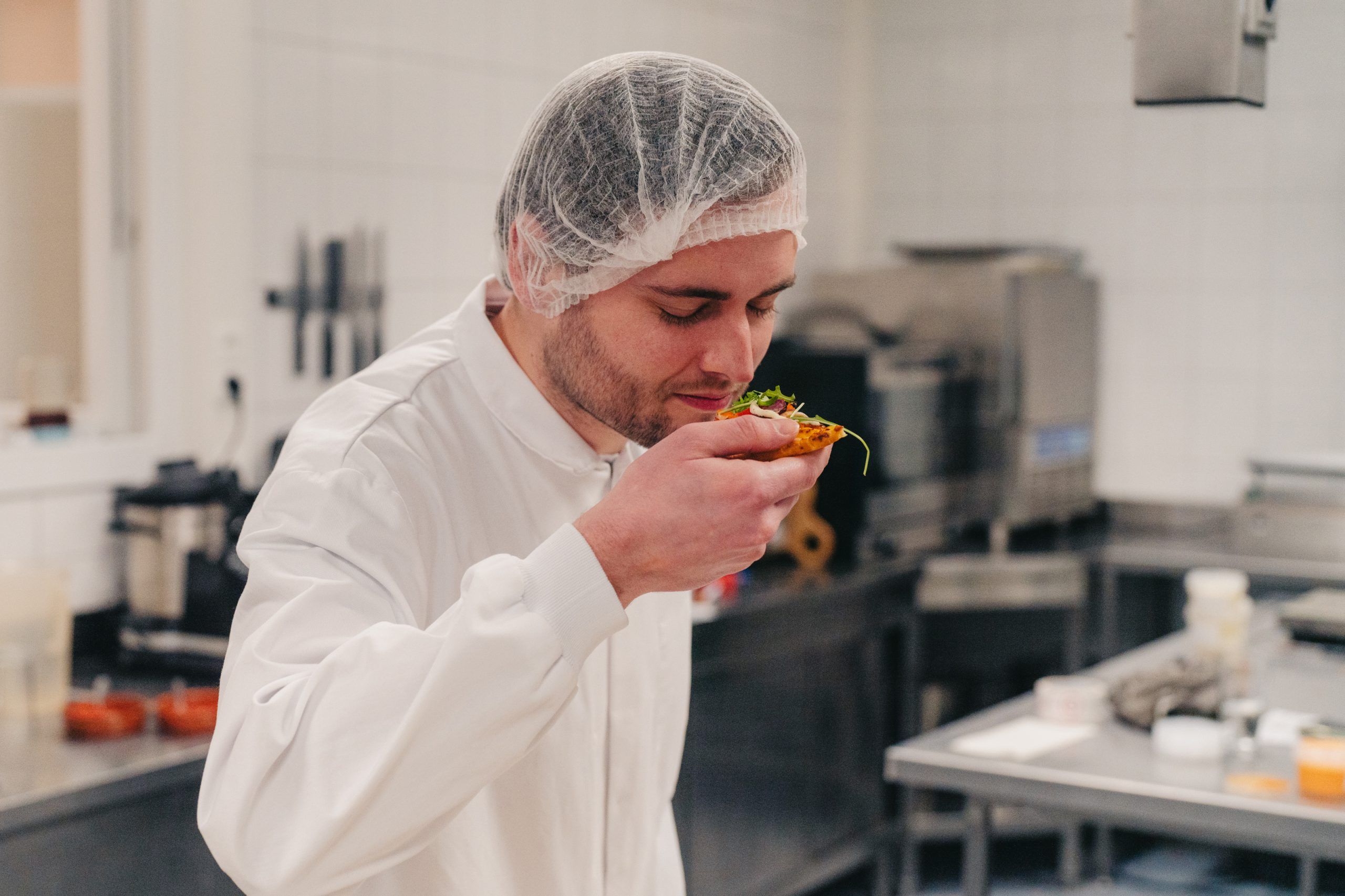 Medewerker ruikt aan stukje pizza